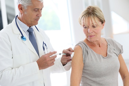 doctor administering a vaccine in a woman's arm